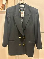 Front view of black Christian Dior blazer on hanger showing double-breasted design and size tag