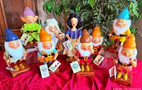 Full set of Snow White and seven dwarfs on display table with tags visible