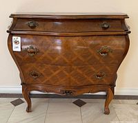 Front view of bombe chest showing three drawers and hardware