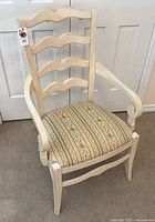 Front view of cream wood ladder-back armchair with striped floral seat