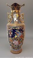 Full view of tall enamel vase showing shape, decoration and handles