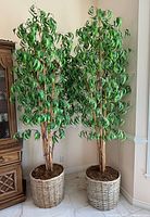 pair of tall artificial bamboo trees in wicker baskets