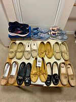 All twelve pairs arranged on table, sneakers at back, loafers and moccasins front
