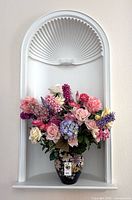 Full view of vase with artificial flowers on shelf