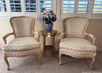 Pair of upholstered armchairs, accent table, vase with flowers