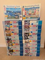 Stack of 22 Ravensburger 300-piece puzzle boxes