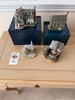 All four miniature buildings displayed, two on boxes