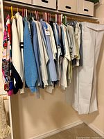 Closet rod with multiple blue, white and patterned jackets, sweaters and tops