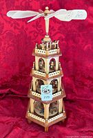 Front view of multi-tier wood Christmas pyramid showing figures and base candle holders