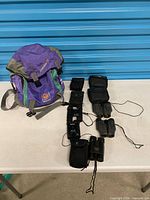 Overview showing Nikko backpack, five binoculars and their pouches