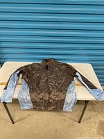 Full view of front of jacket laid flat with ruler for scale