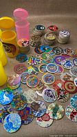 Wide view of loose holographic POG caps, slammers and storage tubes