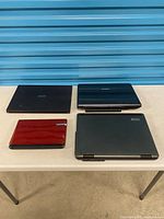Four closed laptops on table