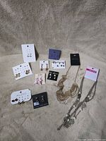 Group view of all earring cards and both necklaces on fabric backdrop