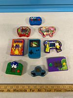 Group shot of all nine handheld games arranged on table