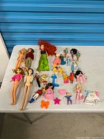Group shot of all dolls, small figures and accessories on table
