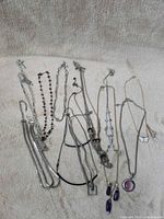 Full group shot of all necklaces laid out on fabric background