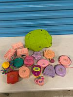 Group of closed compacts, Pollyville modules, pom-pom accessory and large green base on table