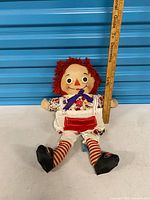 Full view of Raggedy Ann doll next to ruler showing height