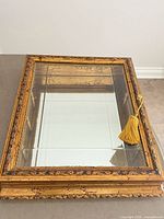 Front view of gilded wood glass display box with mirrored interior