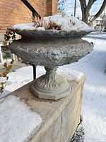 Full view of urn on pedestal showing overall form and snow inside