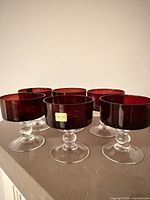Six ruby dessert glasses on display showing color and stems