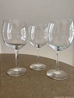 Front view of three clear crystal wine glasses