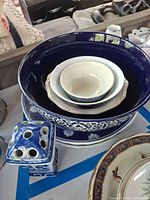 Stacked blue and white bowls and plates with holder visible