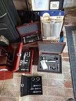 Multiple boxed wine tool sets and packaged 64 oz flask