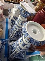 pair of blue and white ceramic candlesticks and partial view of matching pot