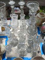 Group of clear glass and crystal candlestick holders on table