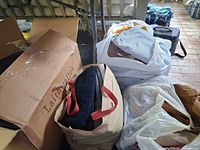 Bags and box filled with assorted men’s clothing items