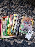 Stack of assorted Disney and bagged Spider-Man comics on rug