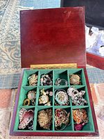 Open jewelry box showing compartments filled with assorted costume jewelry