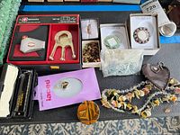 Overview of entire lot showing Wenger set, harmonica, decorative boxes, jewelry pieces