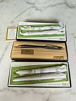 Overview of three Cross boxed sets showing wrapped instruments and Classic Black pen