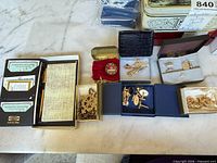 Overview of wallet set, jewelry boxes with cuff links, tie clips, pins, necklace