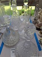 Group of seven clear glass decanters on table