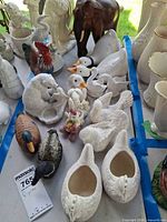 Group shot of assorted white and painted animal figurines on table