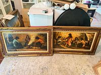 Both framed paintings side by side on floor