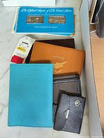 Overall lot showing Hamilton Mint booklet with ingots and assorted wallets/passport holders