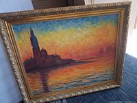 Full view of framed painting showing island silhouette and sunset colors
