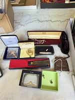 Group shot showing all jewellery items, cutter, sunglasses and boxes