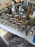 Group view of silver cups, Conica pitchers, lantern, swan holders, grinder and other pieces