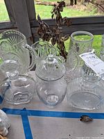 Group view of all six clear glass pitchers and decanters