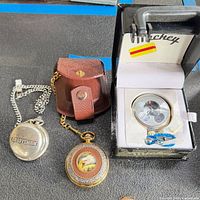 All three pocket watches with pouch, box and chain visible