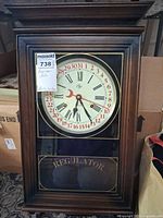 Front view of Elgin regulator clock showing dial and lower glass panel