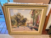 Full view of framed Claude Monet canvas reproduction resting against wall