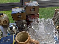 Overview of boxed crystal items, glass bowl on platter, silver sugar bowls