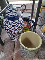 Group view of crock planter, lidded jar, and both pitchers